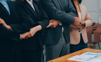 Motivated successful business team giving high five, happy young students employees group join hands with senior teacher mentor, team building unity concept, help support in teamwork, close up view photo