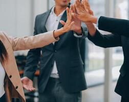 Motivated successful business team giving high five, happy young students employees group join hands with senior teacher mentor, team building unity concept, help support in teamwork, close up view photo