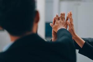 Motivated successful business team giving high five, happy young students employees group join hands with senior teacher mentor, team building unity concept, help support in teamwork, close up view photo