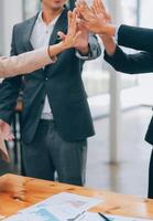 Motivated successful business team giving high five, happy young students employees group join hands with senior teacher mentor, team building unity concept, help support in teamwork, close up view photo