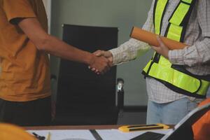 Architect men making handshake in construction site. Employee or worker shake hands to employer man for greeting, dealing, teamwork, collaboration some project or business. They are good team photo