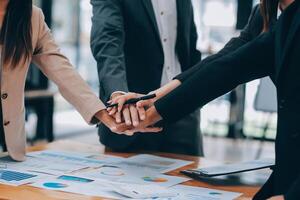 Motivated successful business team giving high five, happy young students employees group join hands with senior teacher mentor, team building unity concept, help support in teamwork, close up view photo
