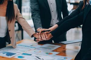 Motivated successful business team giving high five, happy young students employees group join hands with senior teacher mentor, team building unity concept, help support in teamwork, close up view photo