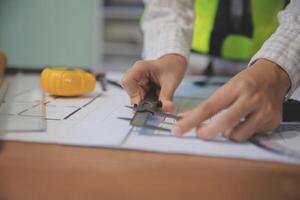 engineer people meeting working and pointing at a blueprint in office for discussing. Engineering tools and construction concept photo