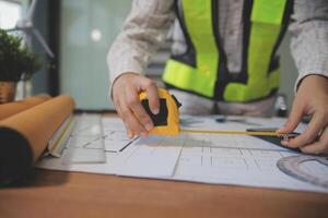 engineer people meeting working and pointing at a blueprint in office for discussing. Engineering tools and construction concept photo