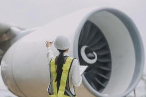 Technician fixing the engine of the airplane,Female aerospace engineering checking aircraft engines,Asian mechanic maintenance inspects plane engine photo