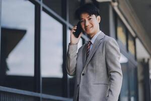 Good news about project. Young businessman talking with client via mobile phone and checking money transfer on tablet. Business, education, lifestyle concept photo