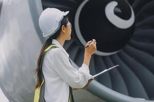 Technician fixing the engine of the airplane,Female aerospace engineering checking aircraft engines,Asian mechanic maintenance inspects plane engine photo