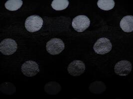 White polka dot carpet texture on black for background. photo