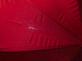 Red umbrella texture with water drops in dark for background. photo