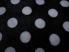 White polka dot carpet texture on black for background. photo