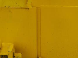 Yellow painted steel texture for a close-up background of a building or construction. photo