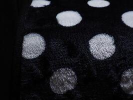 White polka dot carpet texture on black for background. photo