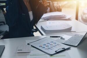 Group of confident business people point to graphs and charts to analyze market data, balance sheet, account, net profit to plan new sales strategies to increase production capacity. photo