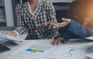 Group of confident business people point to graphs and charts to analyze market data, balance sheet, account, net profit to plan new sales strategies to increase production capacity. photo