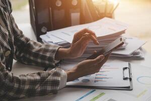 Group of confident business people point to graphs and charts to analyze market data, balance sheet, account, net profit to plan new sales strategies to increase production capacity. photo
