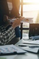 Group of confident business people point to graphs and charts to analyze market data, balance sheet, account, net profit to plan new sales strategies to increase production capacity. photo