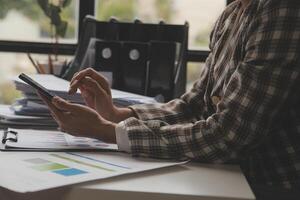 Group of confident business people point to graphs and charts to analyze market data, balance sheet, account, net profit to plan new sales strategies to increase production capacity. photo