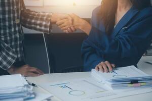 Group of confident business people point to graphs and charts to analyze market data, balance sheet, account, net profit to plan new sales strategies to increase production capacity. photo
