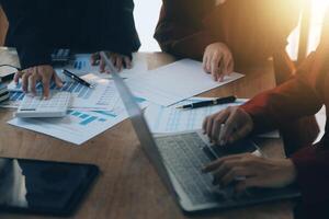 Group of confident business people point to graphs and charts to analyze market data, balance sheet, account, net profit to plan new sales strategies to increase production capacity. photo