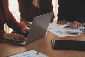 Group of confident business people point to graphs and charts to analyze market data, balance sheet, account, net profit to plan new sales strategies to increase production capacity. photo