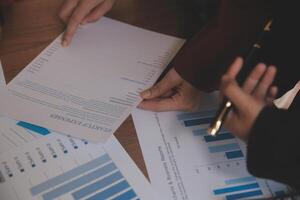 Group of confident business people point to graphs and charts to analyze market data, balance sheet, account, net profit to plan new sales strategies to increase production capacity. photo