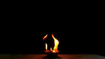 Flames are burning in a bowl isolated on a black background. Concept of particles, sparkles, flame and light. video