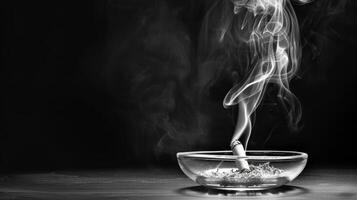 Smoke rising from smoldering cigarette in ashtray photo