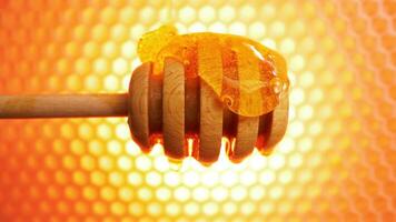 Fresh bee honey flows down over a wooden honey spoon, honeycombs on background video