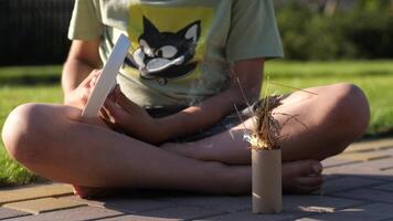 Hand of a boy with a magnifying glass who is trying to set fire to the grass video
