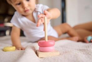 Baby playing with stacking rings, developing motor skills and learning photo