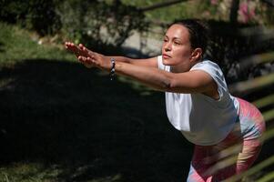 Woman practicing yoga in a peaceful outdoor setting on a sunny day, focusing on balance and mindfulness photo