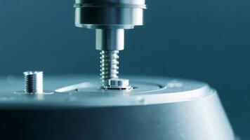 A robotic hand delicately picks up a tiny screw and secures it into place.. video