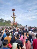 Pariaman, Indonesia - July 21, 2024. The giant statue called Tabuik Pariaman is led by the community to the beach during the Hoyak Tabuik event in Pariaman City, Indonesia photo