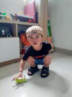 little boy squatting to pick up toys, playing at home photo