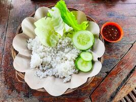 The traditional Indonesian food dish is called Ayam Penyet or fried chicken with rice and vegetables without chicken and tempeh photo