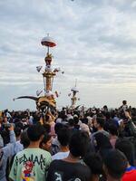 Pariaman, Indonesia - July 21, 2024. The giant statue called Tabuik Pariaman is led by the community to the beach during the Hoyak Tabuik event in Pariaman City, Indonesia photo