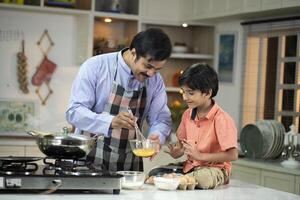 Son With Father Beating Eggs In Bowl photo