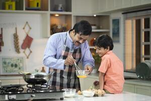 Father With Son Whisk Eggs In Bowl photo
