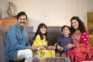 Loving Parents With Kids Posing In Front Of Camera In Traditional Wear photo