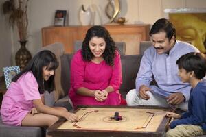 Lovely Family Spending Time Together By Playing Carrom Board Game photo