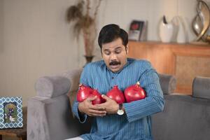 Mature Guy Posing With Clay Piggy Bank In Front Of Camera photo