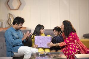 Man Clapping While His Son Giving Gift To His Daughter photo