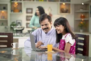 Father Teaching Daughter How To Use Laptop photo