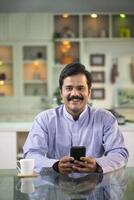 Indian Mature Man Smiling While Looking At Camera photo
