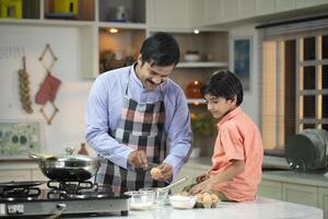 Happy Father Teaches Child To Break Eggs Into A Bowl photo