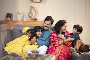 Family Having Fun While Sitting Together On Sofa In Living Room photo