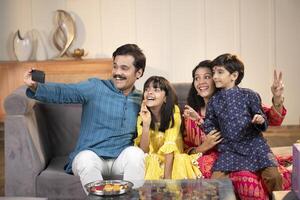 Dad Mother And Kids Posing While Taking Selfie photo