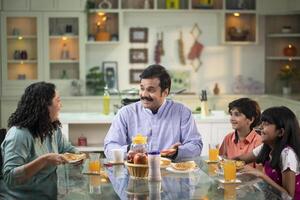 Family Having Breakfast Together At Table photo
