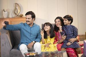 Father Mother Son And Daughter Smiling While Taking Selfie photo